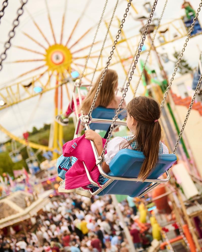 Kind in einem Kettenkarussell auf dem Fränkischen Volksfest