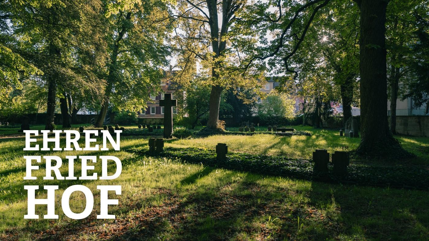 Blick auf den Ehrenfriedhof, auf die Grabsteine scheint die Sonne