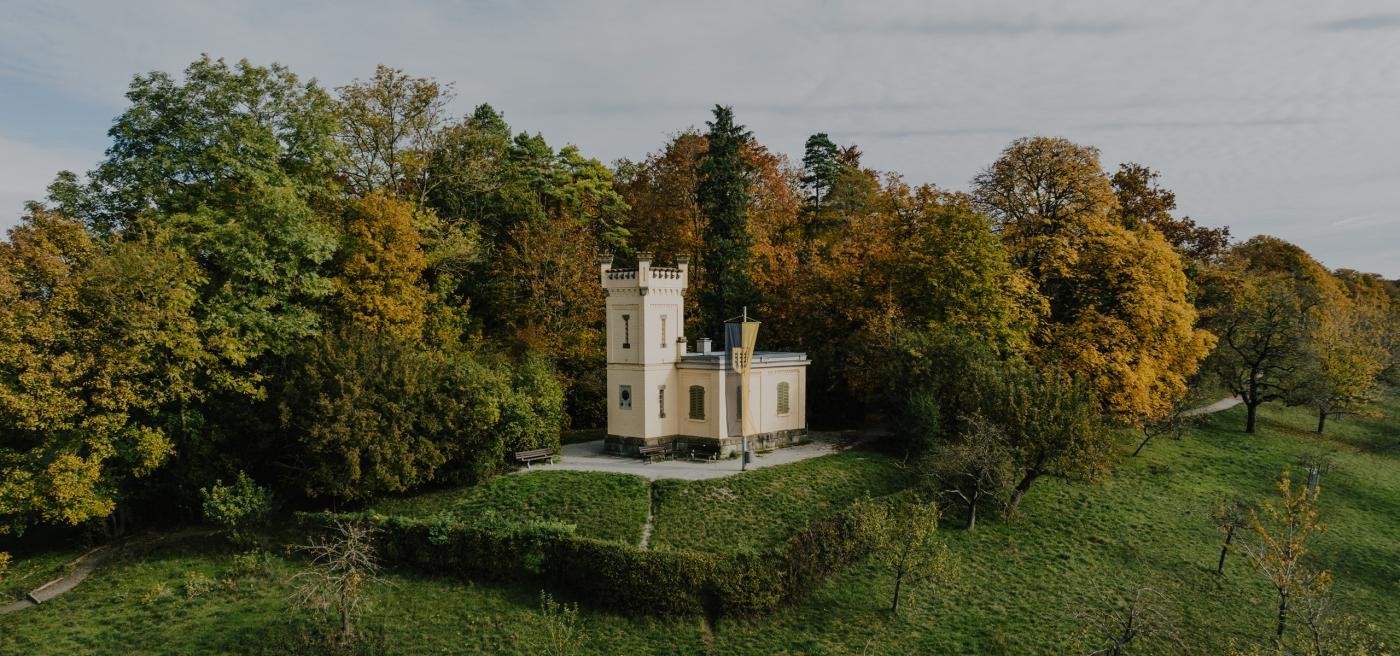 Blick auf das Stadtmuseum im Spital, im Vordergrund sind eine blühende Wiese sowie eine Linde zu sehen.